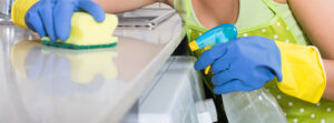 A woman doing a regular cleaning and wiping down the kitchen surfaces.