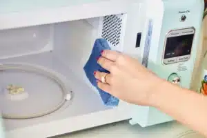 A person cleaning the microwave