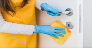 A woman cleaning the doorknob