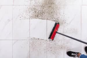 High Angle View Of Broom Cleaning Dirt On Tiled Floor At Home