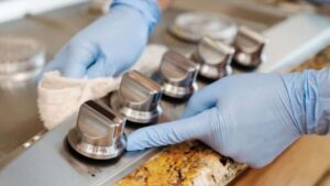 a person deep cleaning a stove